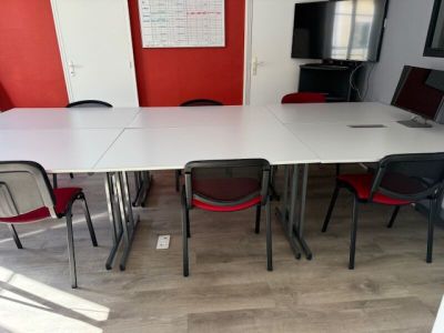 a white table and red chairs in a room