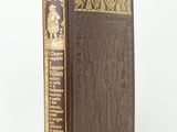 a brown book sitting on top of a table next to a white wall