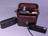 un sac en papier brun contenant un appareil photo et d'autres objets