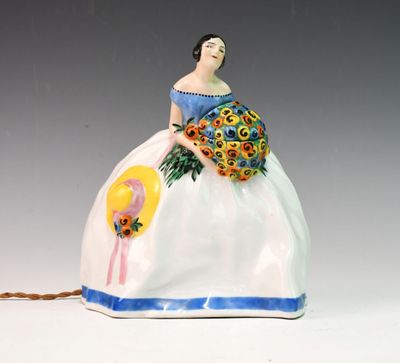 une figurine représentant une femme tenant un bouquet de fleurs