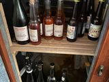 many bottles of alcohol sitting on a shelf in a cabinet