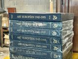 books stacked on top of each other on a shelf in a room