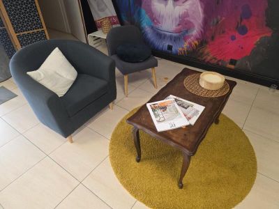 deux chaises et une table dans une pièce où est accroché un tableau au mur