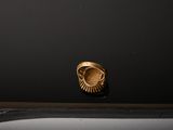 a close up of a gold ring sitting on top of a black surface