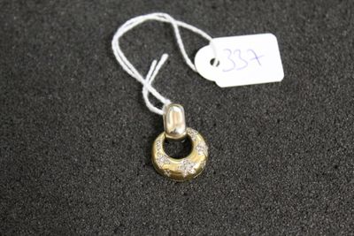 un collier en argent et en or auquel est accrochée une médaille