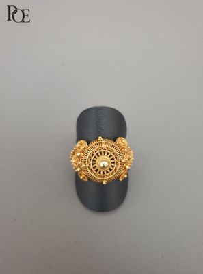 gros plan d'une bague en or sur une surface grise
