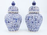 pair of blue and white vases with lids on a white background