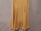 a yellow skirt hanging on a hanger against a wall