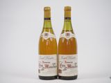 deux bouteilles de vin posées l'une à côté de l'autre sur une surface blanche