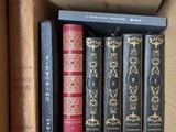 plusieurs livres dans une boîte en carton posée sur une table