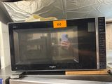 un micro-ondes posé sur une cuisinière dans un magasin