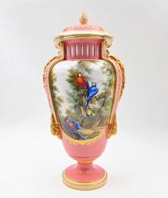 un vase rose orné d'une peinture représentant des oiseaux