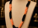 an orange and black beaded necklace on a mannequin
