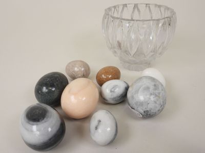 a lot of marbles on the table next to a glass bowl