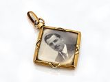 an old photo of a man in a suit and tie in a gold frame