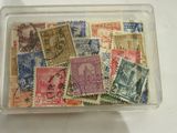 de nombreux timbres différents dans une boîte en plastique posée sur une table
