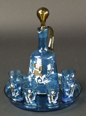 une carafe en verre bleu et or posée sur un plateau