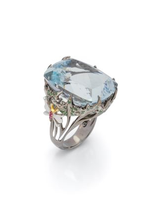 a close up of a ring on a white surface with a blue topaz