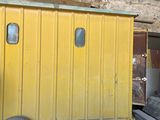 un wagon de queue jaune posé au milieu d'un entrepôt