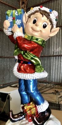 a christmas ornament with a santa clause holding a present