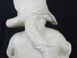 marble bust of a woman with a hat and scarf on a black background