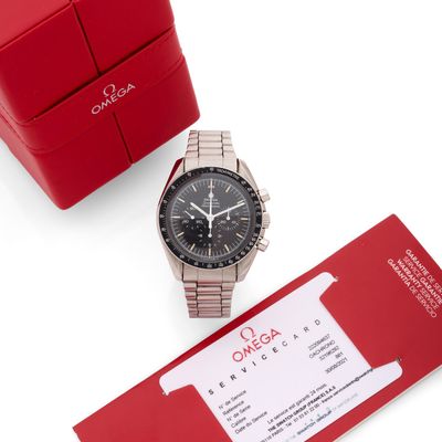 une photo d'une montre posée à côté d'un coffret cadeau rouge
