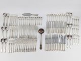 a lot of silver spoons and forks laid out on a table