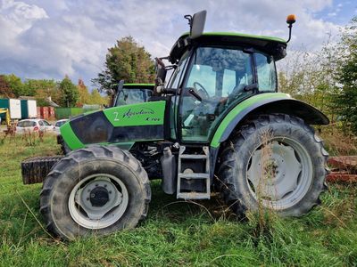 un tracteur vert garé dans l'herbe