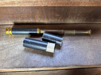 two bullet shells sitting on a wooden table next to each other