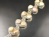 a close up of a bracelet on a table with a black background
