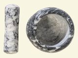 a black and white marble bowl next to a white and black marble tube