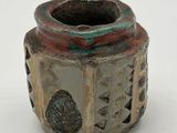 a small vase that is sitting on a white surface