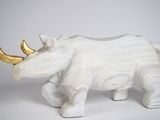 statue d'un rhinocéros blanc à la corne dorée sur fond blanc