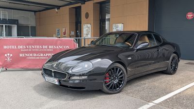 une voiture de sport noire garée devant un immeuble