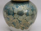 a blue and gold vase with a lid sitting on a table