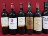 six bouteilles de vin sont alignées sur un support rouge