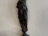 a statue on the wall next to a mirror and a lamp
