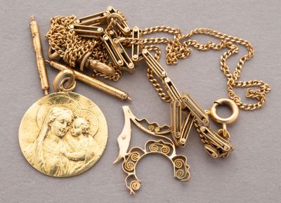 a gold necklace with a coin and a pair of scissors on it