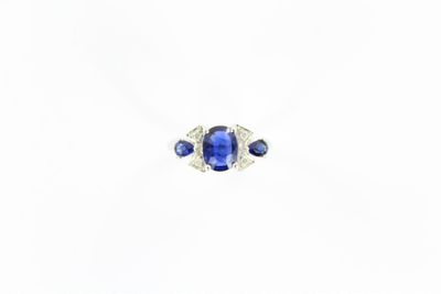 un gros plan d'une bague en saphir et diamants sur fond blanc