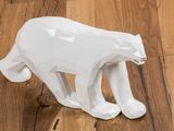 a white bear figurine sitting on a wooden floor