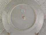 a white plate with a gold rim on a table