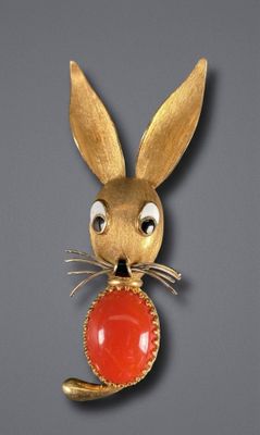 rabbit with a red stone in its mouth on a gray background