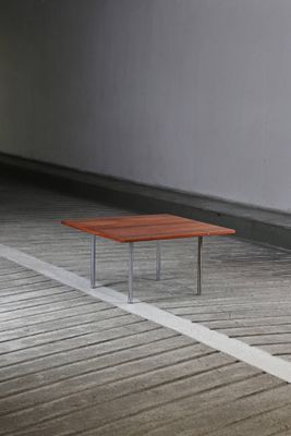 une table en bois posée sur un parquet, dans une pièce vide