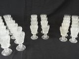 six verres à pied en verre transparent sont alignés sur un fond noir