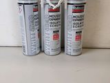 three cans of mousse foam are lined up on a counter