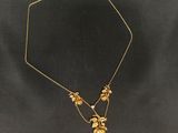 un collier en or orné de fleurs et de feuilles