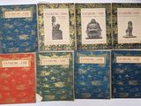 several books are lined up on a table with a white background
