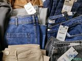 several pairs of jeans are stacked on top of each other