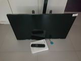 a flat screen tv sitting on the floor next to a remote control