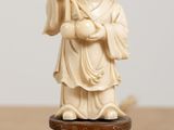 a small statue of a man holding a bird on a table